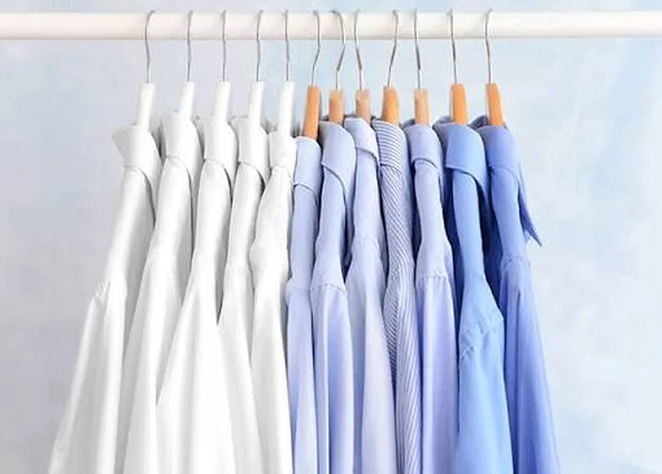 Áo sơ mi trắng và xanh treo móc ngay ngắn sau khi giặt hấp