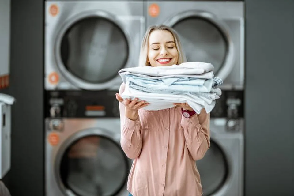 Khách hàng nhận lại đồ sạch gấp gọn tại tiệm giặt